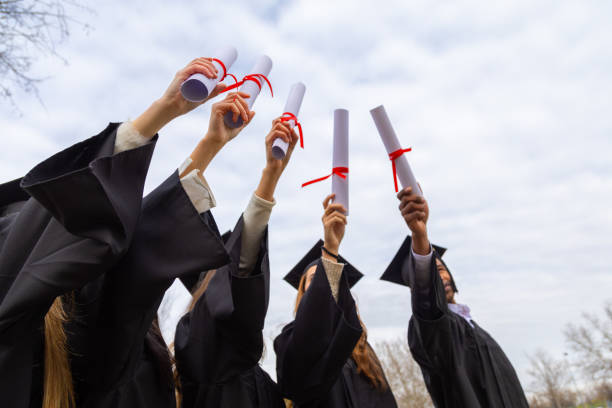 istock Happy graduates raising diplomas outdoors celebrating achievement 2202305798