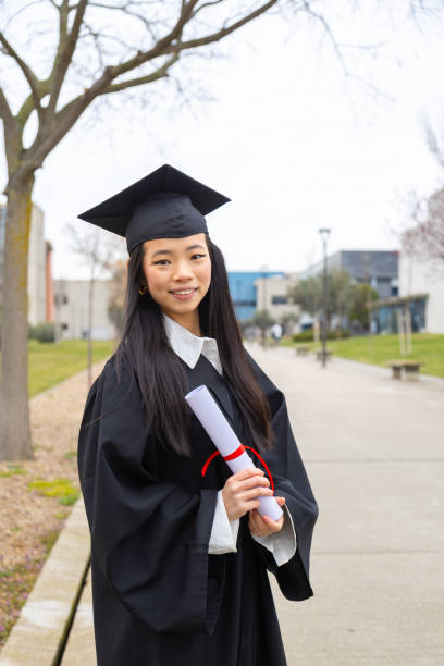 istock Happy asian graduate celebrating with diploma in university campus 2202305804