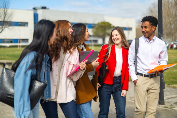 istock Happy students walking and talking on university campus 2202305817