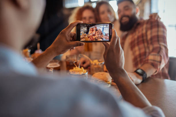istock A Social Moment: Taking a Picture of Smiling Friends at a Pub 2202306776