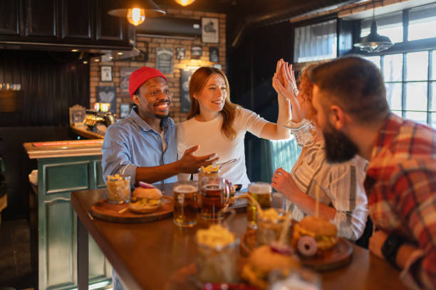 istock Joyful Friends Greeting Each Other at a Cozy Pub 2202307313