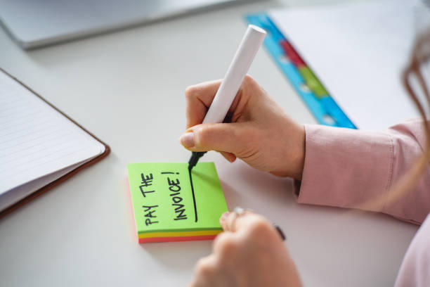 istock Close-Up of Hand Writing Reminder on Sticky Notes in Office 2202308851