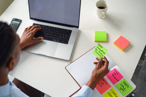 istock Businessman Organizing Tasks with Sticky Notes and Laptop 2202308983