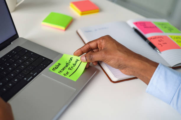 istock African American Professional Using Sticky Notes for Organization in Office 2202309017