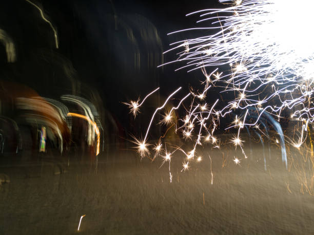 Barcelona, Spain - 09/21/2024 Celebration of the autumn equinox or end of summer, Correfoc.\nVibrant fireworks create dynamic light trails against a dark night sky, showcasing an energetic celebration in Carrer de Gracia.