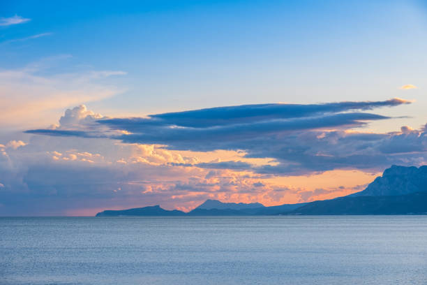 Sunset over the sea. silhouetted mountains on the horizon
