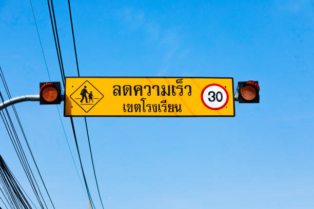 Reduce speed in school zone sign and warning signals in Bangkok near elementary school