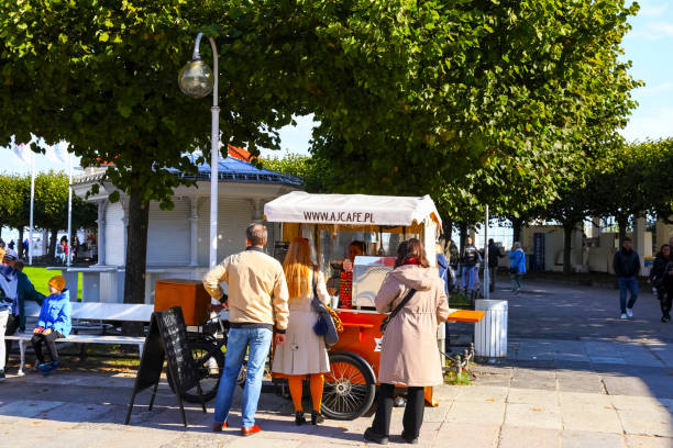Sopot, Poland - October 6, 2024: A small cafe has been set up on the sidewalk. This type of small, three-wheeled coffee shop is a mobile outlet for take-away coffee.