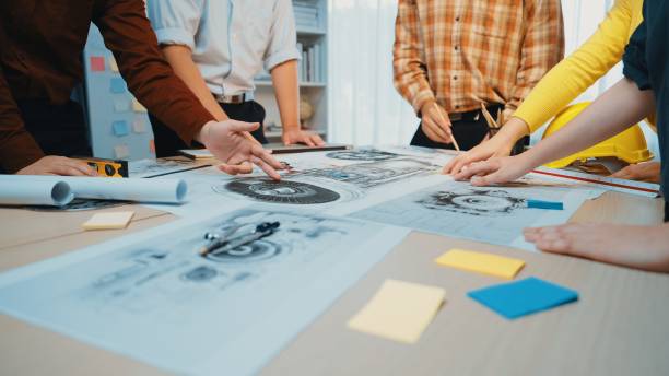 istock Collaborative Teamwork Around Table with Drawings and Blueprints in Modern Office Space, Focus on Hands and Creative Process SACTR 2202318153