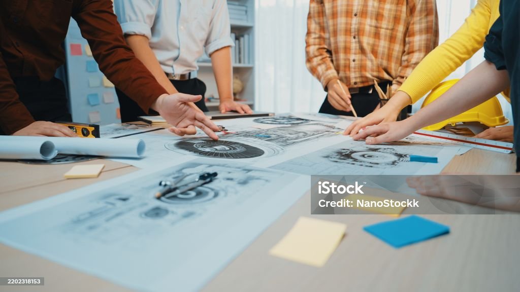 Tablework Collaborative Teamwork Around Table With Drawings And Blueprints In ...