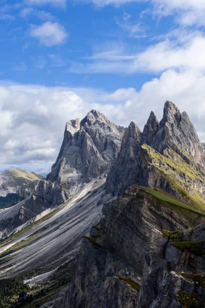 istock Seceda iconic ridge and lush plateau with a grassy meadow create a striking contrast against steep cliffs and a dynamic sky (Vertical photo) 2202318363