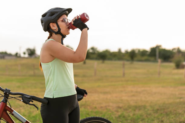 istock Female cyclist hydrating during outdoor ride 2202319507