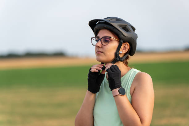 istock Female cyclist adjusting her helmet before a ride 2202319519
