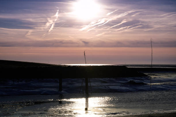 Beautiful sunset, low tide and small ice floes in the fairway to Dorum harbor, Cuxhaven-Germany.