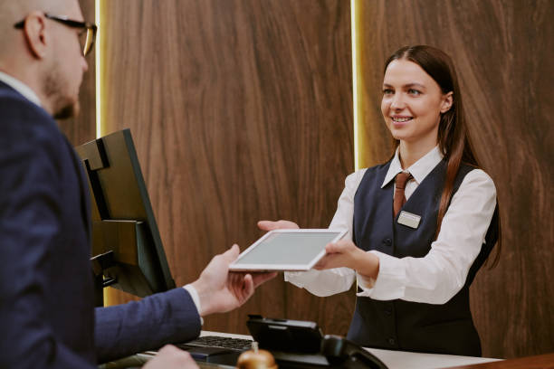 istock Receptionist Giving Tablet to Hotel Guest 2202327544