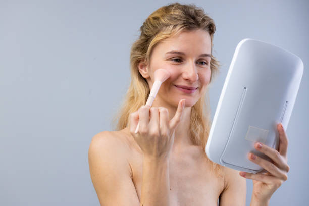 istock A Woman Applying Makeup in Front of a Mirror: Embracing Natural Beauty with Makeup Techniques and Skincare Choices for a Confident Appearance 2202329503