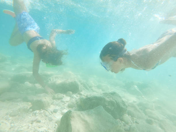 istock Young caucasian children moving down underwater 2202329847