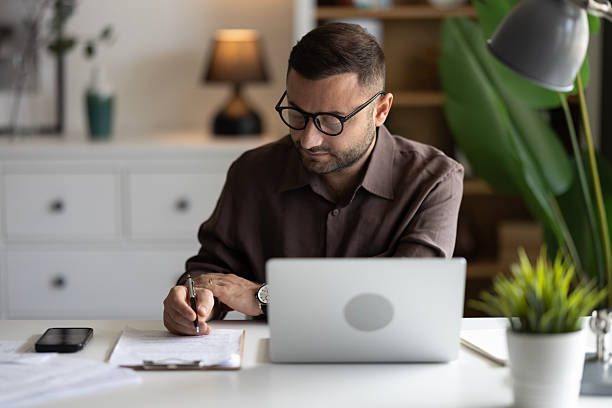 istock Businessman looking at laptop, working online from his home 2202332234