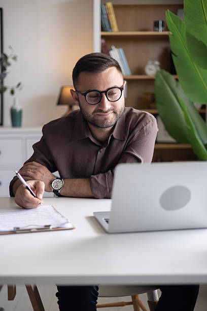 istock Businessman looking at laptop, working online from his home 2202332351