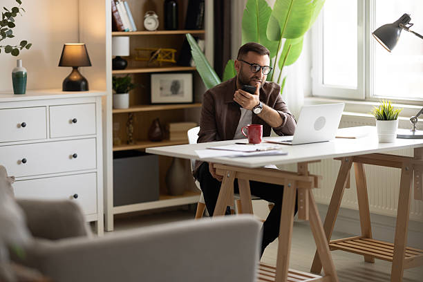 istock Businessman looking at laptop, working online from his home 2202332438