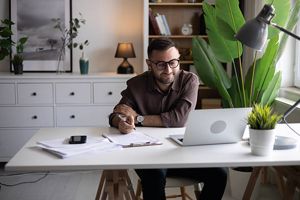 istock Businessman looking at laptop, working online from his home 2202333353