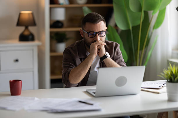 istock Businessman looking at laptop, working online from his home 2202333412