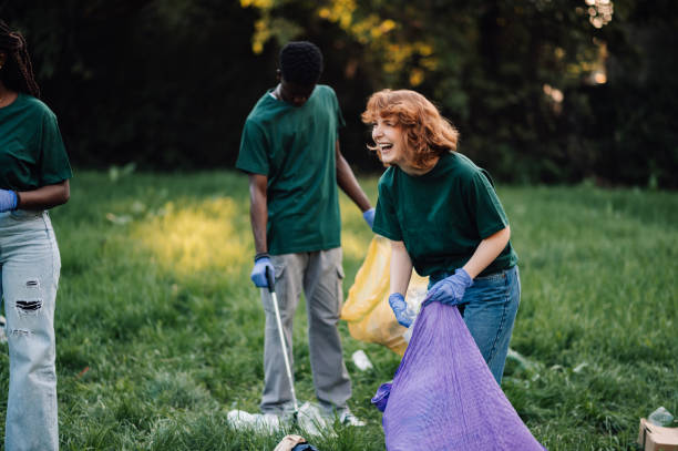 istock Volunteers collecting garbage in the park having fun 2202333565