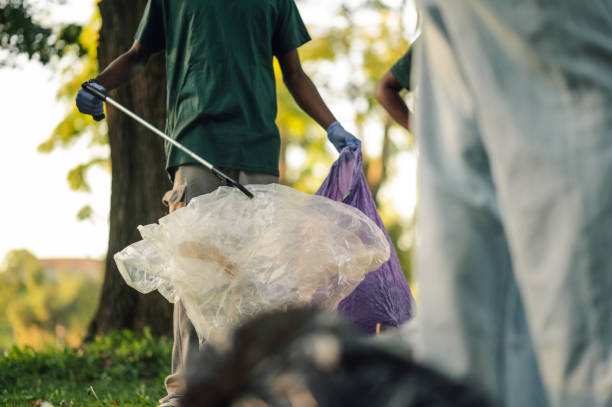 istock Volunteers cleaning park picking up trash using garbage bags 2202333586