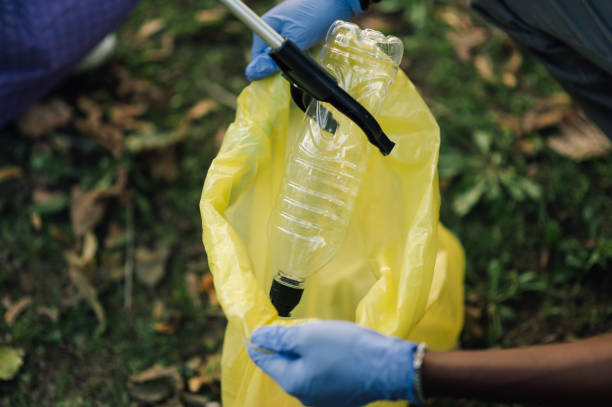 istock Volunteers collecting plastic bottle in garbage bag in nature 2202333618