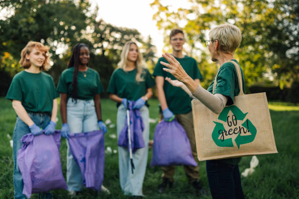 istock Group of volunteers picking up trash in park are discussing about environmental issues 2202333685