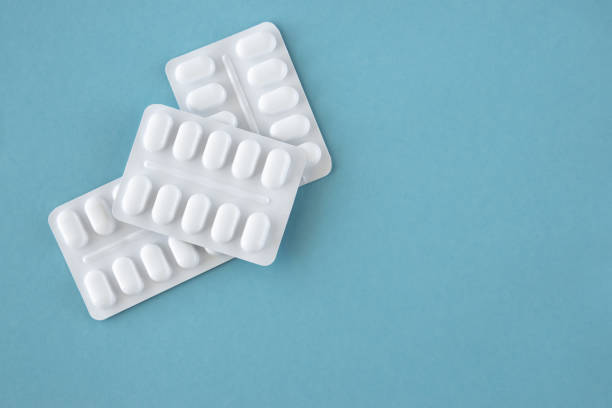 istock Tabletten or pillen in white package on the paper blue background. 2202336015