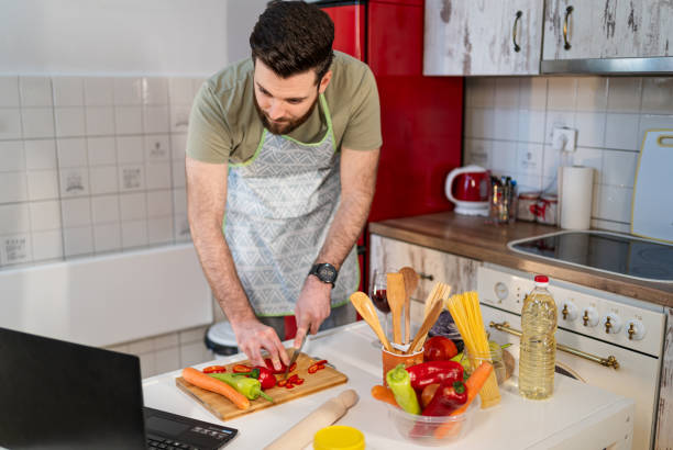 istock Young man following online recipe 2202336219