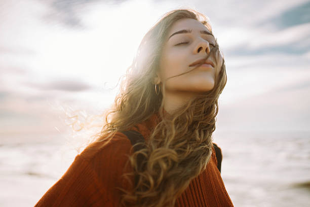 istock Cute woman with backpack enjoying sunset light on lighthouse, feeling freedom. 2202338056
