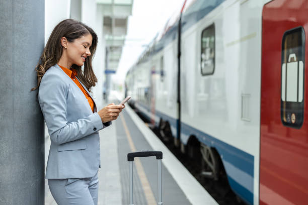 istock Professional woman waiting by a train while using her phone 2202343205