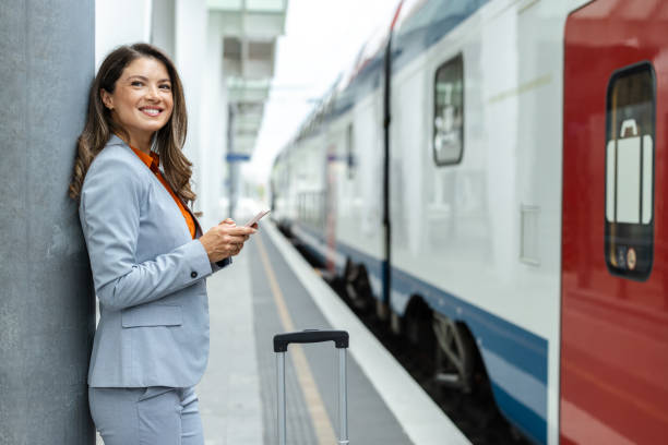 istock Professional woman waiting by a train while using her phone 2202343206