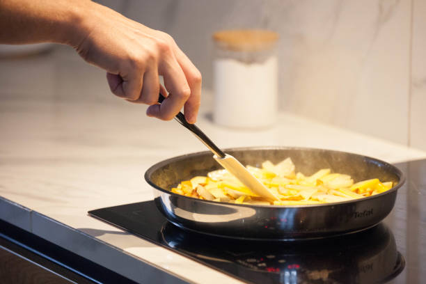 istock A man fries potatoes on a home stove 2202355406