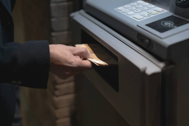 istock Businessman withdrawing cash from atm at night 2202356174