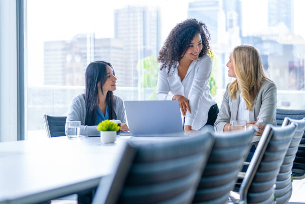 istock Three business  women meeting. They are discussing something while looking at a laptop computer. 2202357546