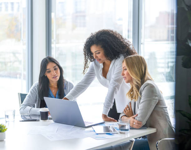 istock Three business  women meeting. They are discussing something while looking at a laptop computer 2202357614