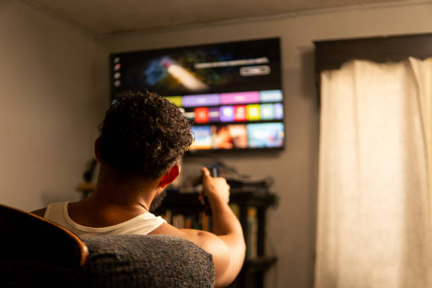 istock Man browsing streaming service on smart tv in living room 2202357663
