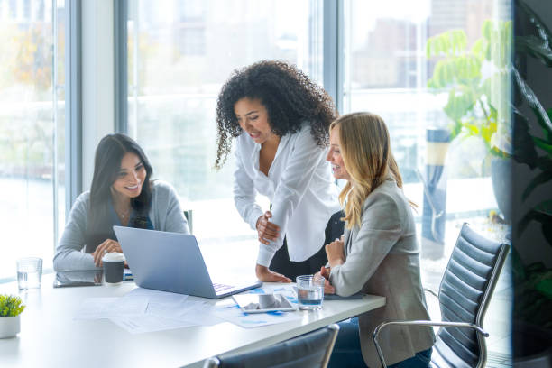 istock Three business  women meeting. They are discussing something while looking at a laptop computer. 2202357670