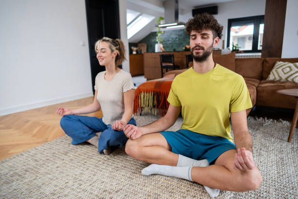 istock Young couple meditating together in a cozy home environment 2202358974