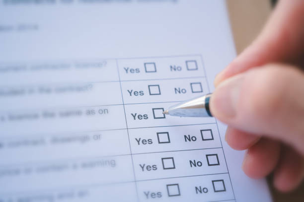 close up and selective focus hand using pen to making tick mark on check list box check list and marker