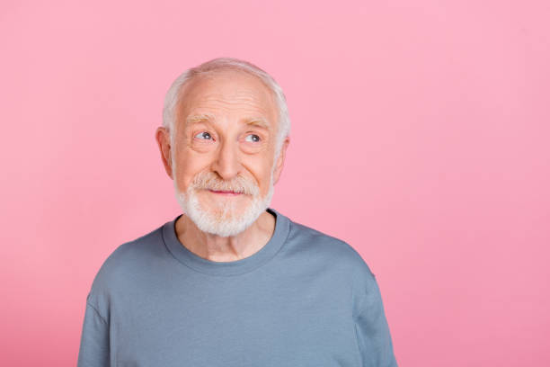 istock Photo of cheerful dreamy guy pensioner dressed grey pullover looking empty space isolated pink color background 2202360889