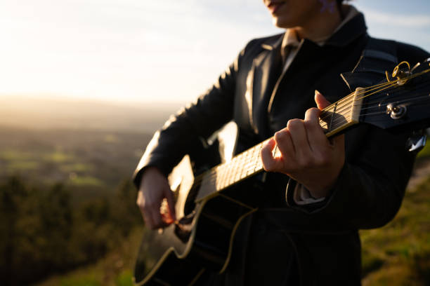istock Skilled guitarist performing acoustic melody against dramatic mountain backdrop, golden sunset light illuminating musical moment with natural beauty and artistic expression 2202362268