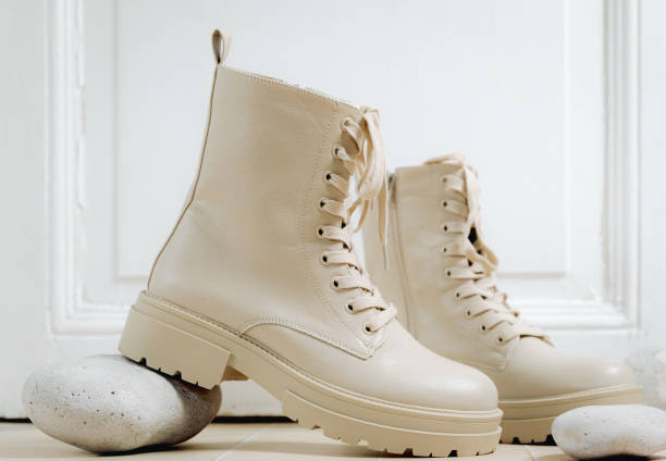 istock Beige boots on a tiled floor with stones. 2202367922