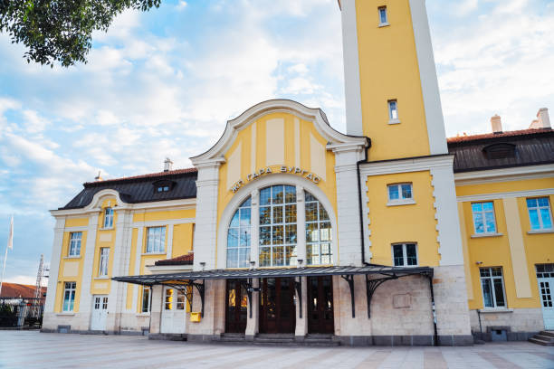 Burgas railway station features bright yellow architecture under a clear sky, welcoming travelers with charm.