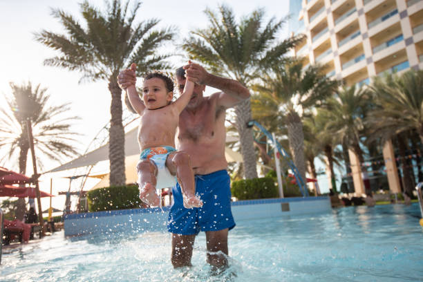istock Single father playing with boys in the swimming pool at sunset. 2202374161