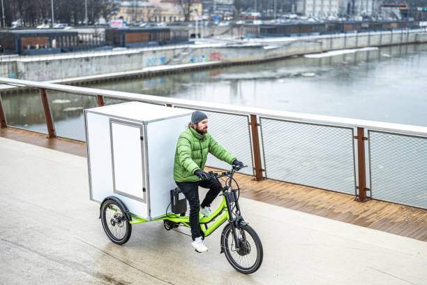 istock Bicycle courier delivering parcels in the city on a cargo bike 2202376030