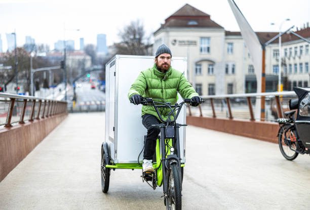 istock Bicycle courier delivering parcels in the city on a cargo bike 2202376031